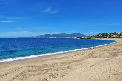 a beach with people walking on the sand and the ocean at Stella - Agosta beach by foot Terrace - by TGB in Porticcio