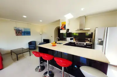 a kitchen with red bar stools and a counter at Stella - Agosta beach by foot Terrace - by TGB in Porticcio