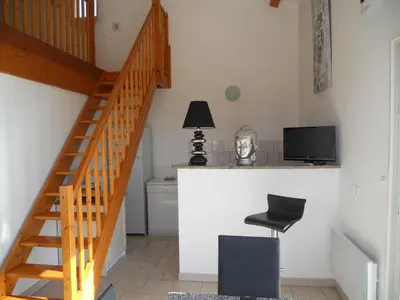a room with a staircase and a desk with a television at Gîtes Sassone, piscine, jacuzzi et vue mer panoramique sur Ajaccio in Alata