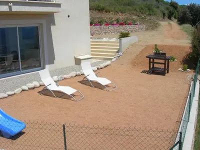 two white chairs and a table on a patio at Gîtes Sassone, piscine, jacuzzi et vue mer panoramique sur Ajaccio in Alata