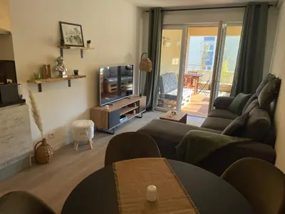 a living room with a couch and a television at Charmant T2 proche de la plage et au calme in Ajaccio