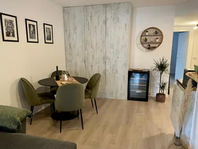 a dining room with a table and chairs and a tv at Charmant T2 proche de la plage et au calme in Ajaccio