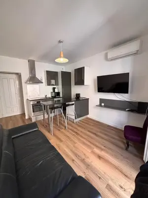 a living room with a black couch and a table at Appartement T2 Vieux Port d'Ajaccio in Ajaccio