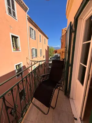 a balcony with a chair sitting on a balcony at Appartement T2 Vieux Port d'Ajaccio in Ajaccio