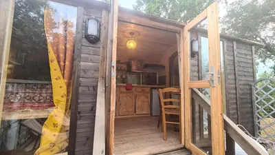 an open door of a tiny house with a surfboard at La roulotte au coeur du maquis in Carbuccia