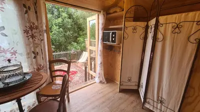a room with a table and a door to a balcony at La roulotte au coeur du maquis in Carbuccia
