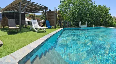 a swimming pool in a yard with a gazebo at La roulotte au coeur du maquis in Carbuccia