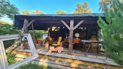 a wooden house with a toy car on a deck at La roulotte au coeur du maquis in Carbuccia