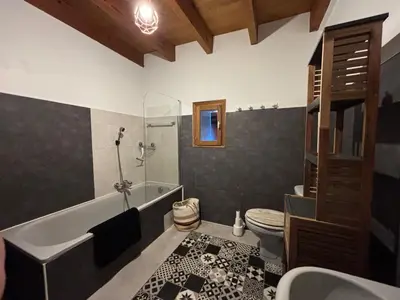 a bathroom with a tub and a toilet and a sink at Belle maison de montagne proche Ajaccio in Bastelica