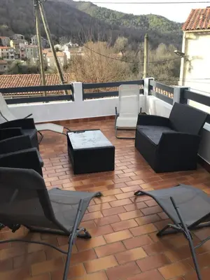 a patio with chairs and tables on a balcony at Belle maison de montagne proche Ajaccio in Bastelica