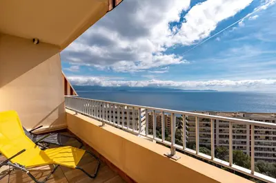 a balcony with a yellow chair and a view of the ocean at Ajaccio, Sanguinaires, Hélios, vue mer magnifique, T2 4pers in Ajaccio