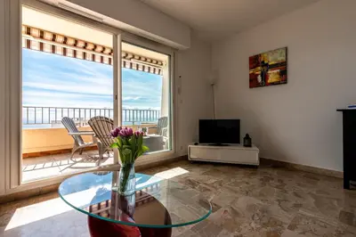a living room with a glass table and a television at Ajaccio, Sanguinaires, Hélios, vue mer magnifique, T2 4pers in Ajaccio