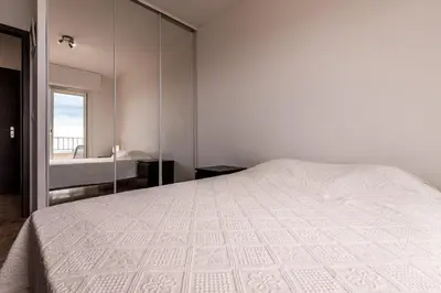 a bedroom with a white bed and a mirror at Ajaccio, Sanguinaires, Hélios, vue mer magnifique, T2 4pers in Ajaccio