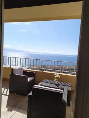 a balcony with tables and chairs and a view of the ocean at Ajaccio, Sanguinaires, Hélios, vue mer magnifique, T2 4pers in Ajaccio