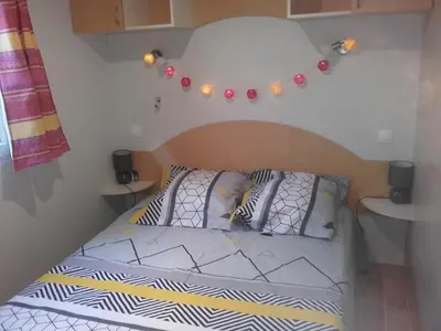 a bed with two pillows on it in a room at Mobil-Home dans lotissement très tranquille in Vescovato