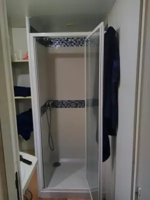 a shower with a glass door in a bathroom at Mobil-Home dans lotissement très tranquille in Vescovato