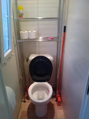a small bathroom with a toilet with a black seat at Mobil-Home dans lotissement très tranquille in Vescovato