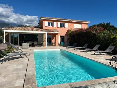 a living room with a couch and a table at Villa Chez Géraldine Piscine chauffée, proche plage et rivière in Lecci