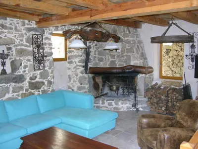 a living room with a blue couch and a stone fireplace at Maison Le Rêve in Evisa