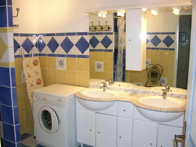 a bathroom with two sinks and a washing machine at Maison Le Rêve in Evisa