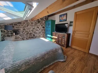 a bedroom with a bed and a stone wall at Maison Le Rêve in Evisa