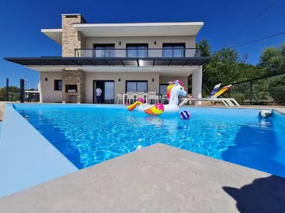 a house with a swimming pool in front of a house at Villa Mekasteni in Cirendinu