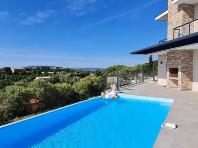 a blue swimming pool in front of a house at Villa Mekasteni in Cirendinu