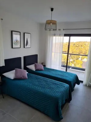 a bedroom with two beds and a large window at Villa Mekasteni in Cirendinu