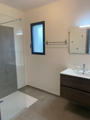 a bathroom with a shower and a sink and a mirror at Villa Mekasteni in Cirendinu