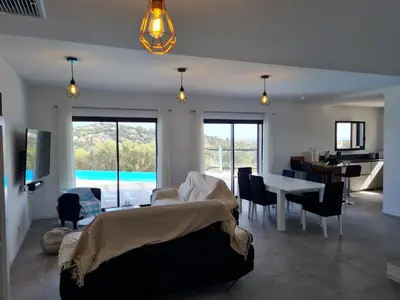 a living room with a bed and a table with chairs at Villa Mekasteni in Cirendinu