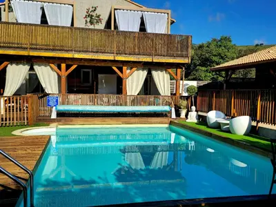 a swimming pool in front of a house at GITES O FIL DE L'EAU piscine spa accès rivière in Omessa