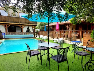 a table and chairs in front of a pool at GITES O FIL DE L'EAU piscine spa accès rivière in Omessa