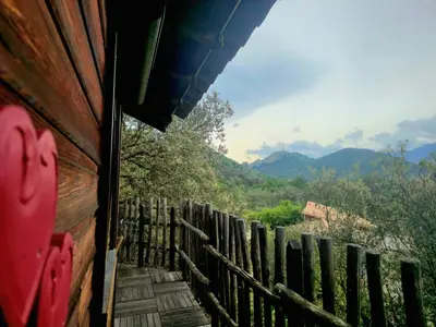 a view of a fence and mountains from a house at GITES O FIL DE L'EAU piscine spa accès rivière in Omessa