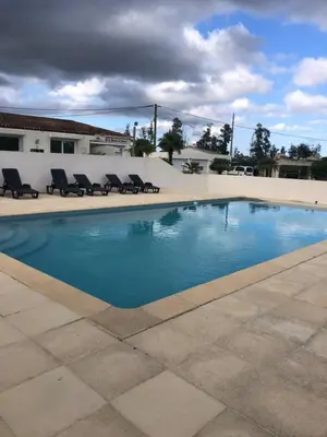 a swimming pool with chairs in front of a building at Butia in San-Giovanni