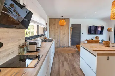 a kitchen with white counters and wooden floors at Villa Tinoeva Mare di Conca in Conca