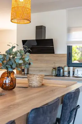 a kitchen counter with chairs and a vase with a plant at Villa Tinoeva Mare di Conca in Conca