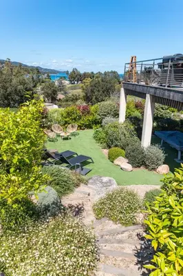 a garden with a bridge and a table and chairs at Villa Tinoeva Mare di Conca in Conca