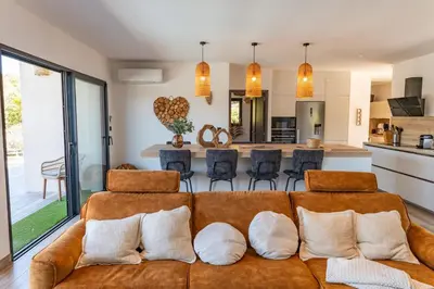 a living room with a brown couch with pillows at Villa Tinoeva Mare di Conca in Conca