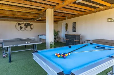 a pool table in a living room with a table at Villa Tinoeva Mare di Conca in Conca