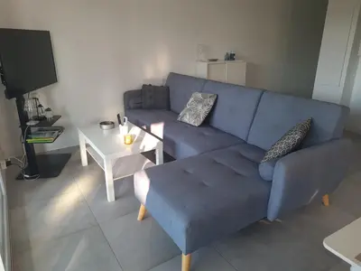 a living room with a blue couch and a table at Location 