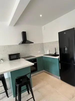a kitchen with green cabinets and a black refrigerator at Appartement Soveria in Soveria