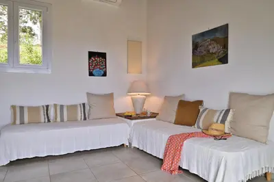 a living room with two white couches and a table at Domaine Punta della Guardia villa panorama maquis et mer, plage à 1,5 Km in Cervione