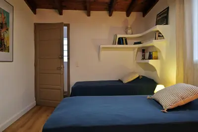 a bedroom with two beds and a book shelf at Domaine Punta della Guardia villa panorama maquis et mer, plage à 1,5 Km in Cervione