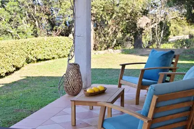 a porch with chairs and a table with fruit on it at Domaine Punta della Guardia villa vue mer dans nature protégée, plage à 1,5 km in Cervione