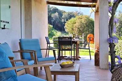 a patio with chairs and a table and a tableablish at Domaine Punta della Guardia villa vue mer dans nature protégée, plage à 1,5 km in Cervione