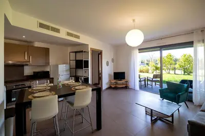 a kitchen and living room with a table and chairs at Domaine d'Arca Porto Vecchio - T2 - Rez de Jardin - 4 personnes 