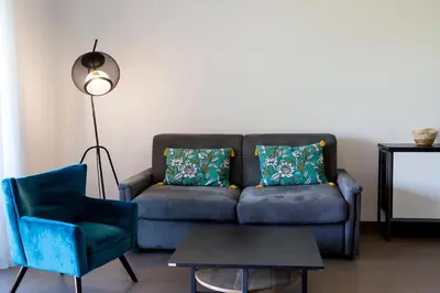 a living room with a couch and a chair at Domaine d'Arca Porto Vecchio - T2 - Rez de Jardin - 4 personnes 