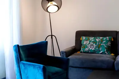 a living room with a chair and a floor lamp at Domaine d'Arca Porto Vecchio - T2 - Rez de Jardin - 4 personnes 