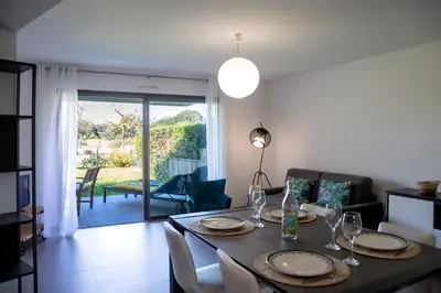 a dining room with a table and chairs and a room with a patio at Domaine d'Arca Porto Vecchio - T2 - Rez de Jardin - 4 personnes 