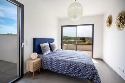 a bedroom with a bed and a large window at Domaine d'Arca - Hugo 13 - 6 pers in Porto-Vecchio